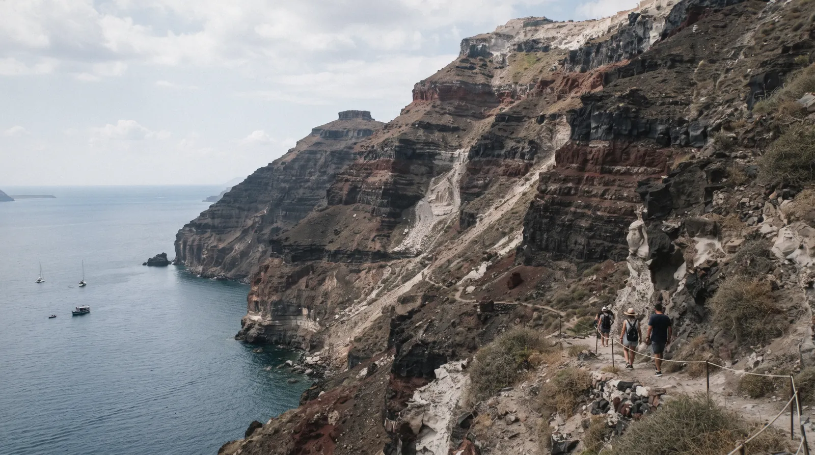 The layered caldera cliffs near Fira showing bands of red, santorini earthquake, Santorini Greece