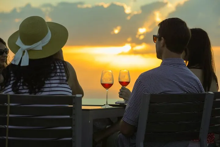 Glasses of Santorini white wine on a caldera terrace on a sunset wine tasting tour, Santorini Greece