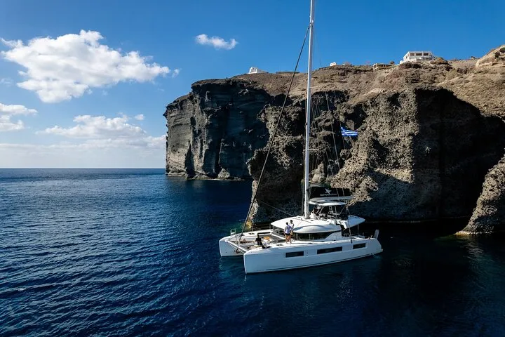 Catamaran anchored in the caldera below Thirassia on a half-day Santorini catamaran cruise, Santorini Greece