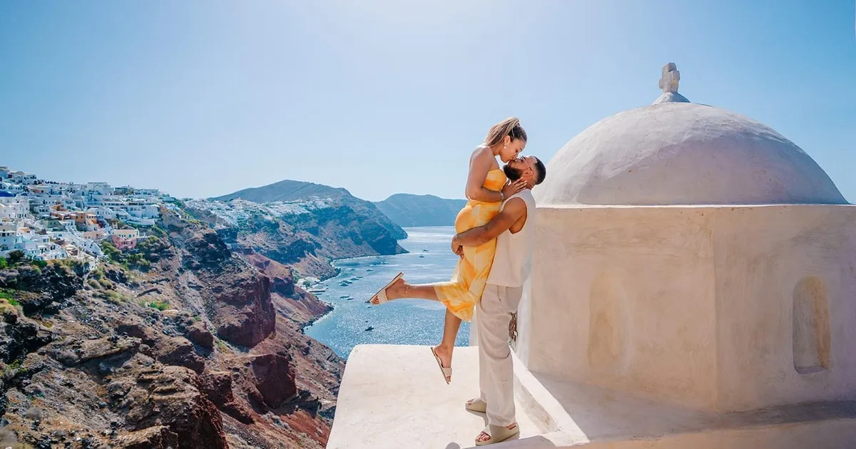 Couple on a terrace above the Oia caldera on a private photoshoot, Santorini Greece